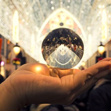 A hand holding a crystal ball to the light
