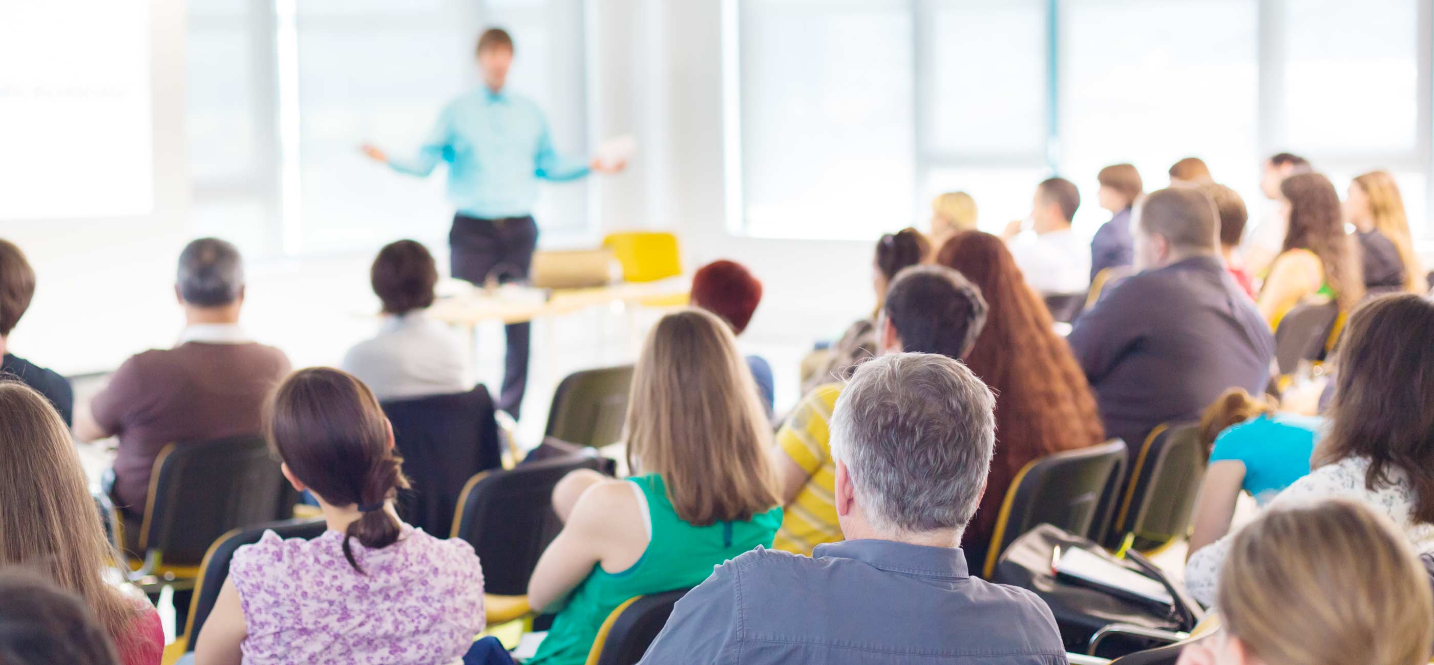 A teacher presenting to a class of adults